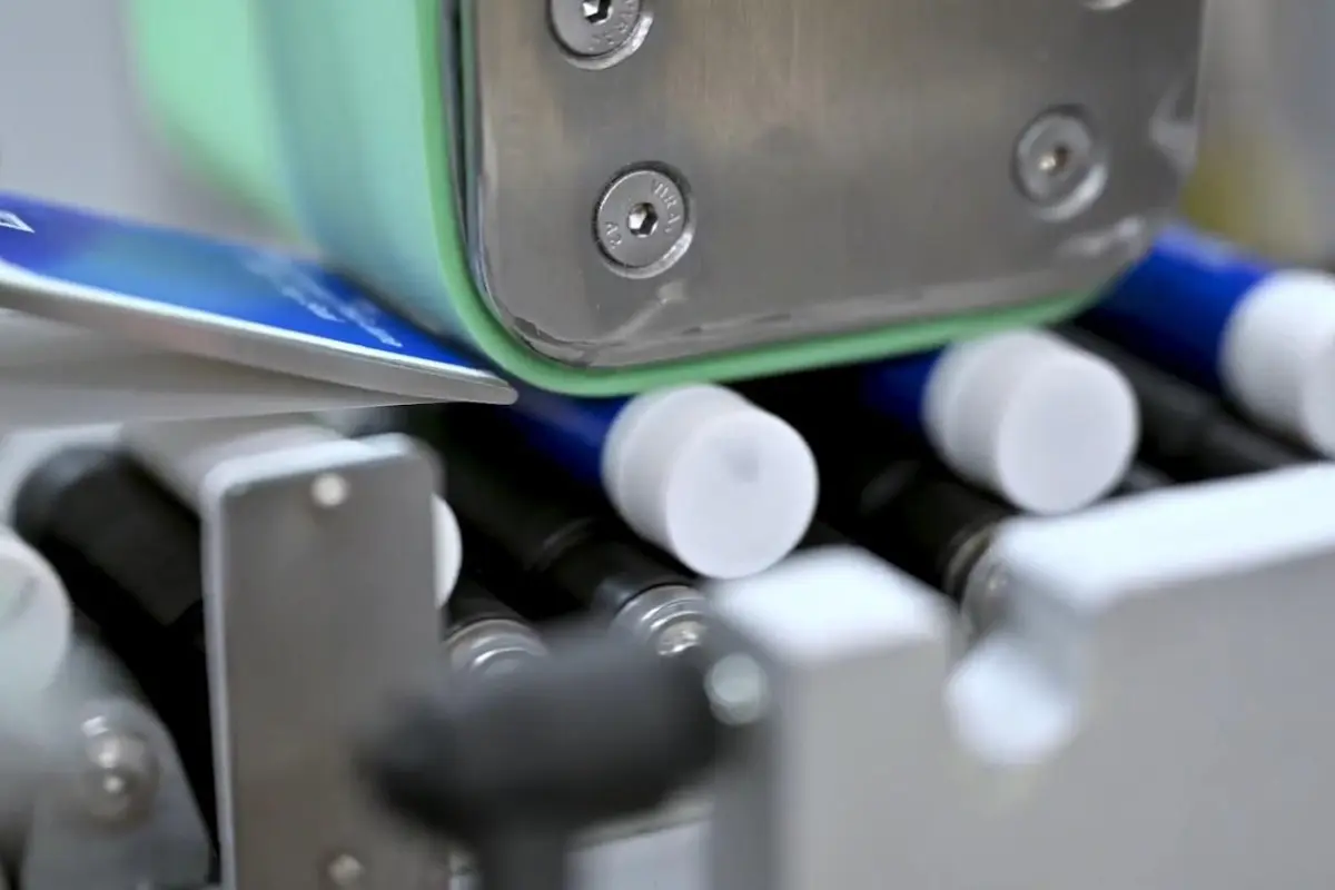 Detailaufnahme einer vollautomatischen Etikettierung von zylindrischen Produkten mittels der Etikettiermaschine Geset 225