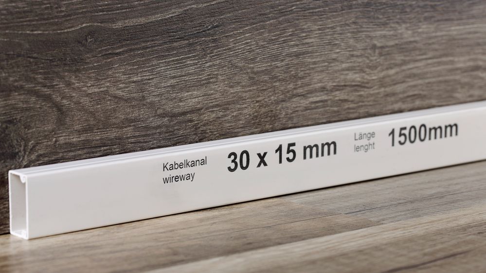 Zwarte inkjetetikettering op een witte kabelgoot